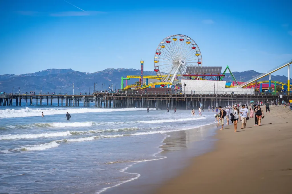 Praia em dia de sol com o Pier de Santa Monica ao fundo 